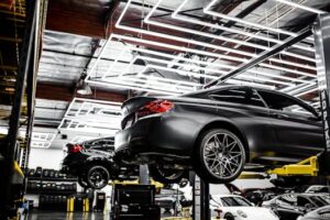 A modern car repair shop showcasing vehicles on lifts and a well-lit, organized interior.