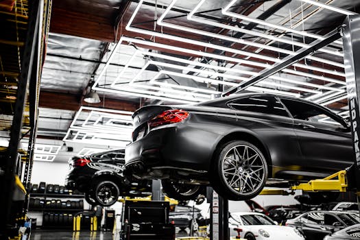 A modern car repair shop showcasing vehicles on lifts and a well-lit, organized interior.